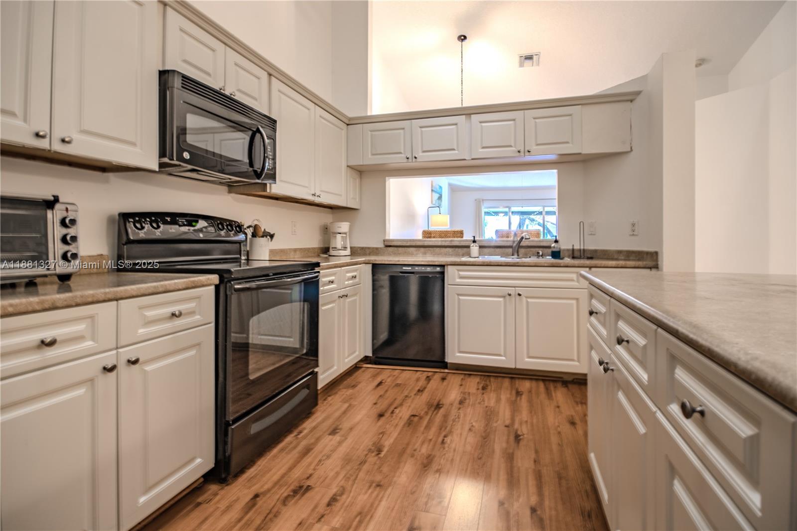 a kitchen with stainless steel appliances granite countertop wooden cabinets granite counter tops and a hard wood floors