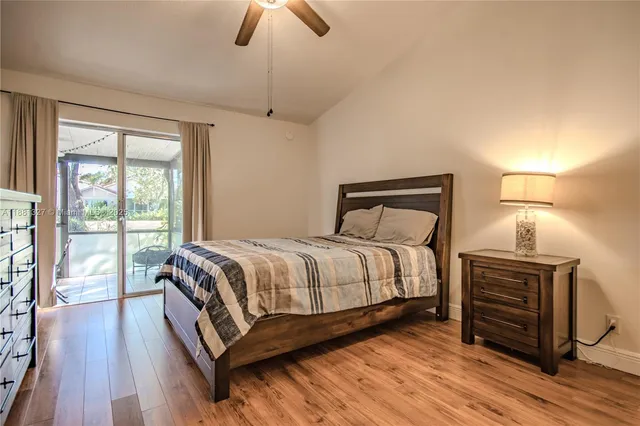 a bedroom with a bed wooden floor and window
