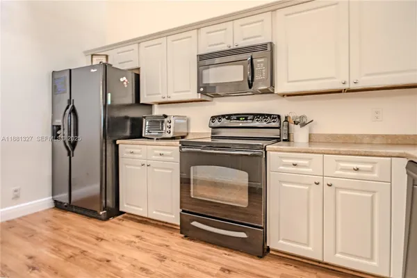 a kitchen with granite countertop white cabinets stainless steel appliances and sink