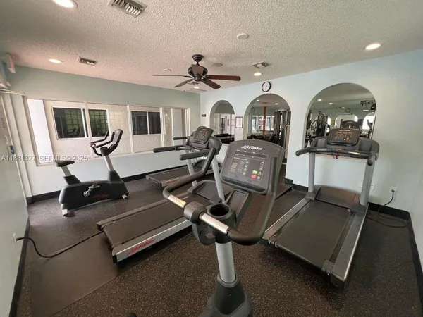 a living room with furniture gym equipment and view of kitchen