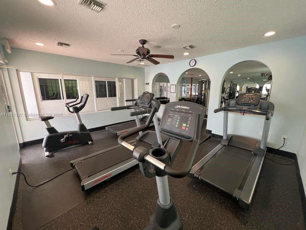 7652 Pinewalk Drive South, Unit 139 Margate, FL 33063 - Photo 25 of 26 a living room with furniture gym equipment and view of kitchen