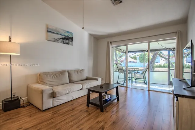 a living room with furniture and a wooden floor