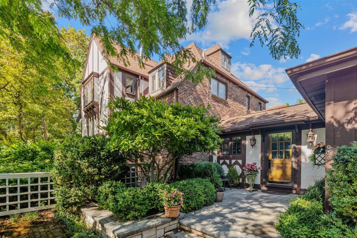 299 Vernon Avenue Glencoe, IL 60022 - Photo 2 of 42 a view of a brick house with plants and large trees