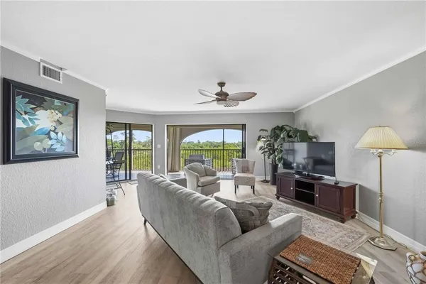 a living room with furniture a large window and a flat screen tv