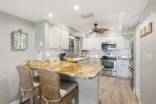 a dining hall with stainless steel appliances kitchen island granite countertop a dining table and chairs