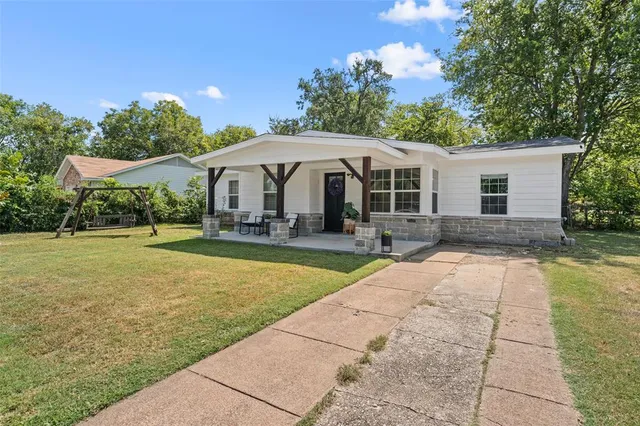 a front view of house with yard seating and green space