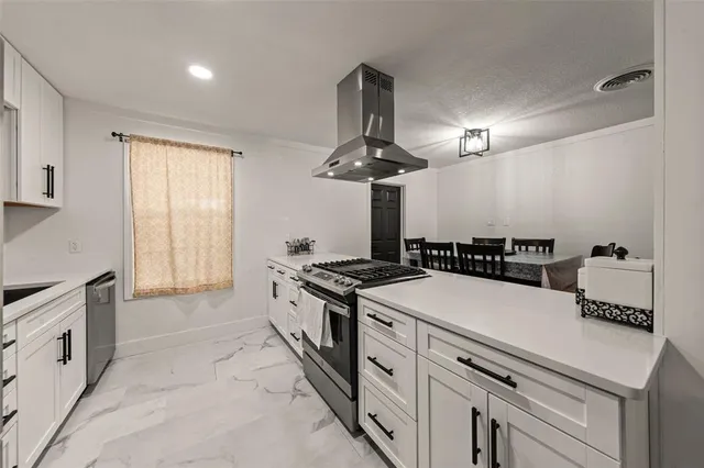 a kitchen with stainless steel appliances a refrigerator a stove a sink and a refrigerator