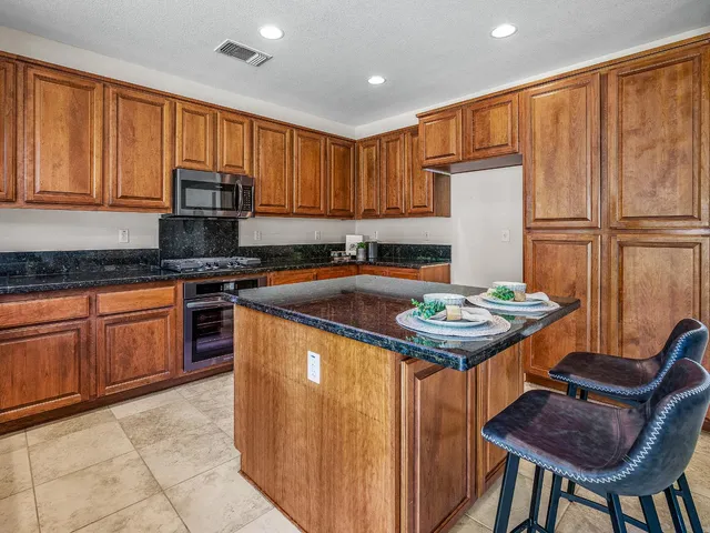a kitchen with stainless steel appliances granite countertop a stove a sink dishwasher and a refrigerator