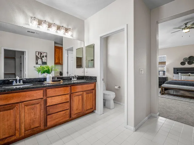 a spacious bathroom with a granite countertop sink and a mirror