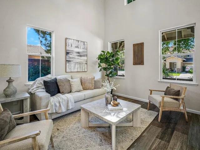a living room with furniture a table and a large window