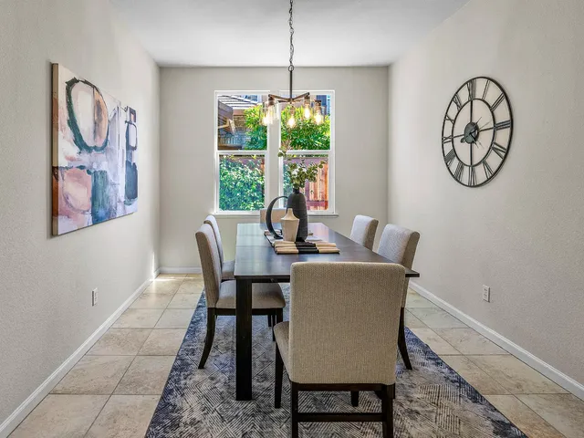 a dining room with furniture a potted plant and a chandelier