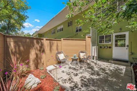 a backyard of a house with table and chairs