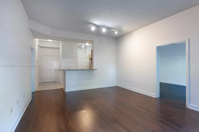 an empty room with wooden floor & windows