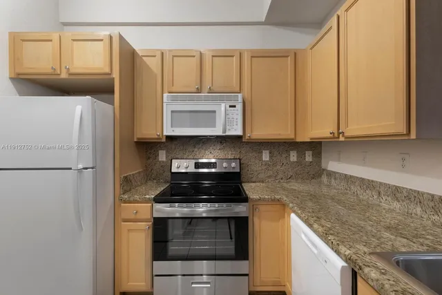 a kitchen with stainless steel appliances granite countertop a refrigerator stove and microwave