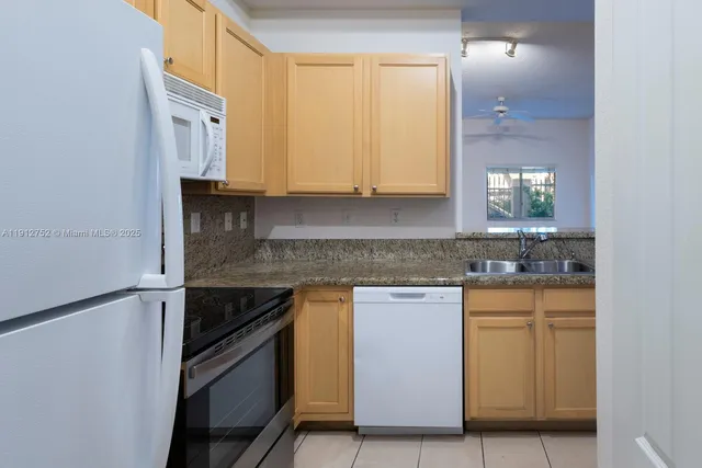 a kitchen with cabinets appliances and a sink