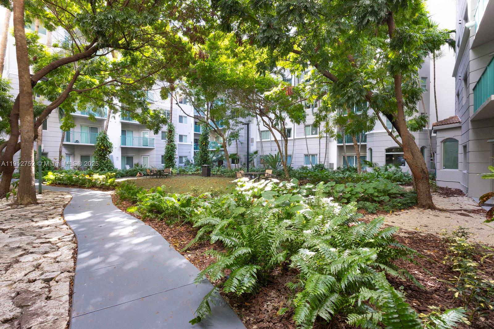 6001 Southwest 70th Street, Unit 139 South Miami, FL 33143 - Photo 22 of 29 a front view of a house with a yard and fountain in middle