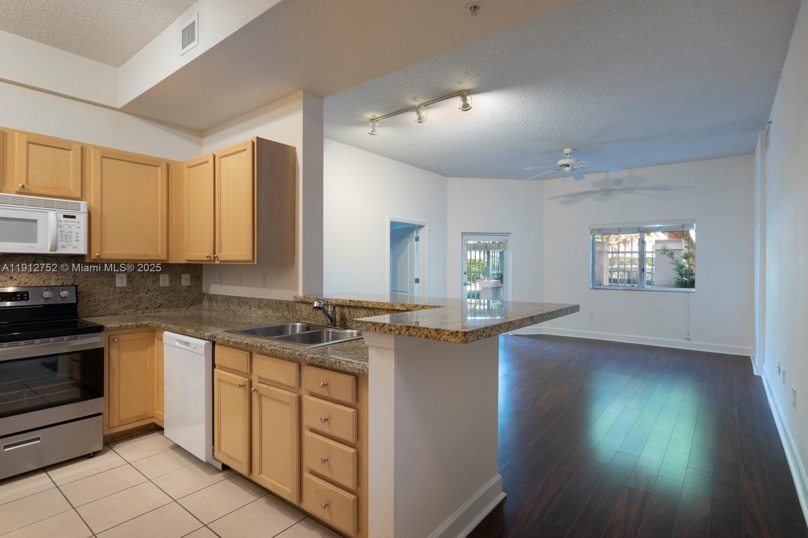 6001 Southwest 70th Street, Unit 139 South Miami, FL 33143 - Photo 7 of 29 a kitchen with a sink stove and cabinets