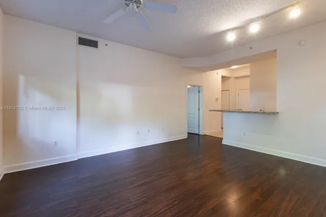 an empty room with wooden floor & windows