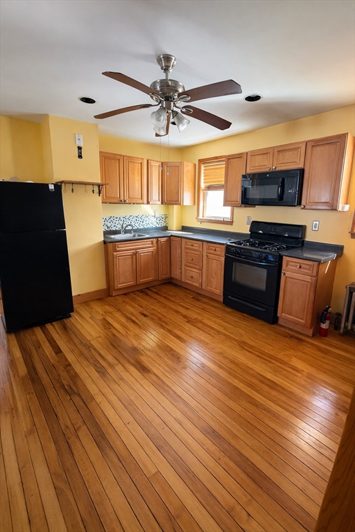 67 Prospect Street Somerville, MA 02143 - Photo 3 of 11 a kitchen with stainless steel appliances wooden floor and large windows
