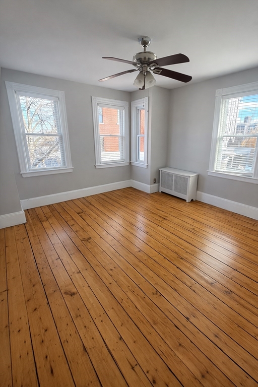 67 Prospect Street Somerville, MA 02143 - Photo 4 of 11 a view of an empty room with wooden floor and a window