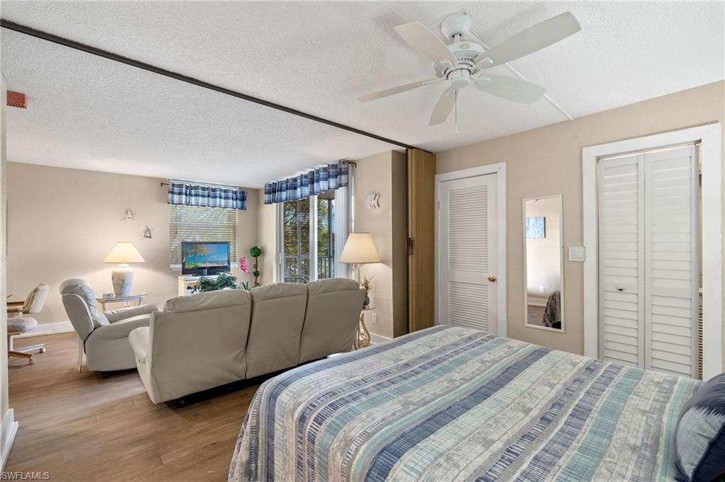 5500 Bonita Beach Road Southwest, Unit 208 Bonita Springs, FL 34134 - Photo 10 of 14 a bed room with a bed and a chandelier