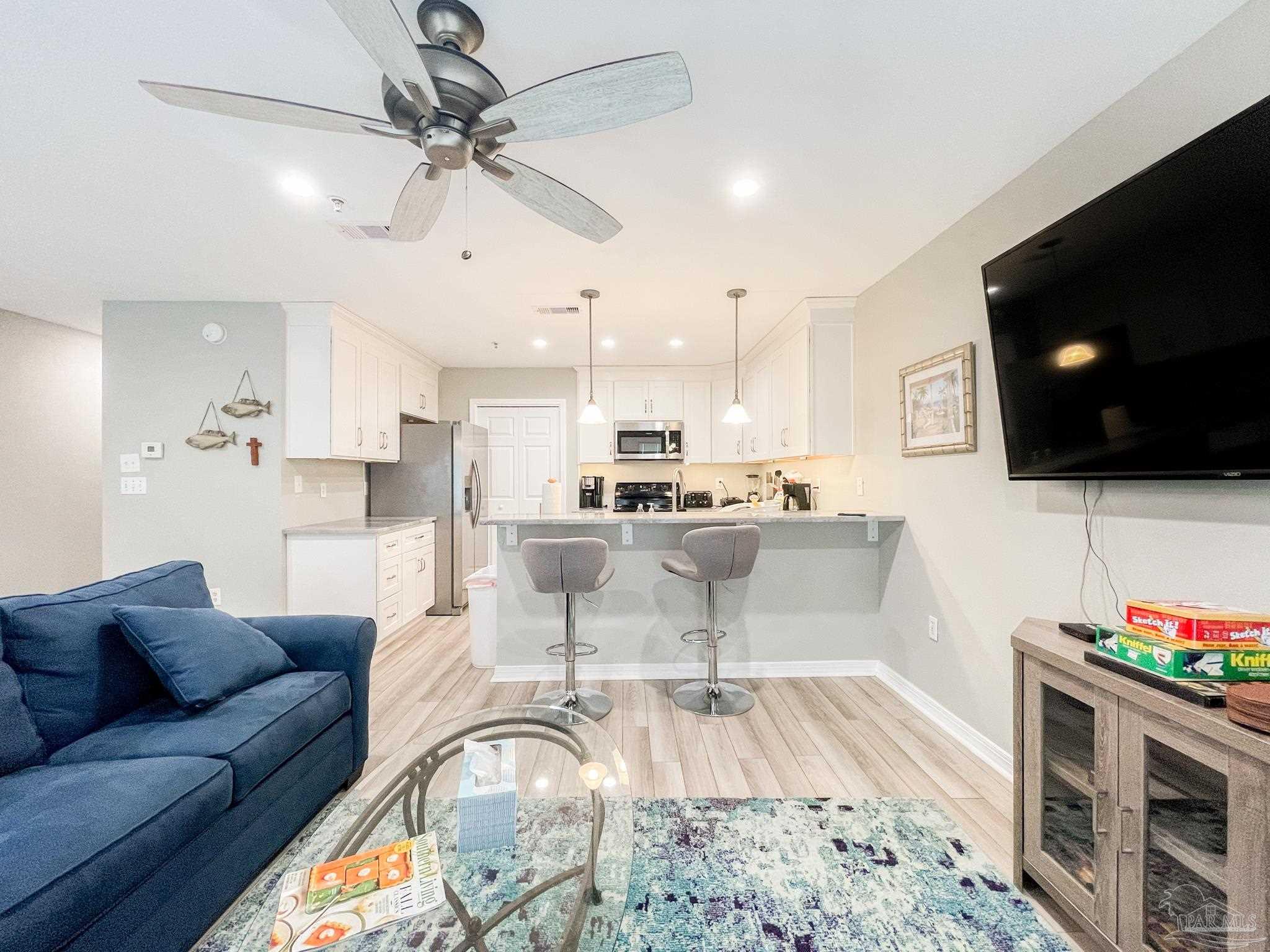 13351 Johnson Beach Road, Unit 402E Pensacola, FL 32507 - Photo 11 of 30 a living room with furniture and a flat screen tv