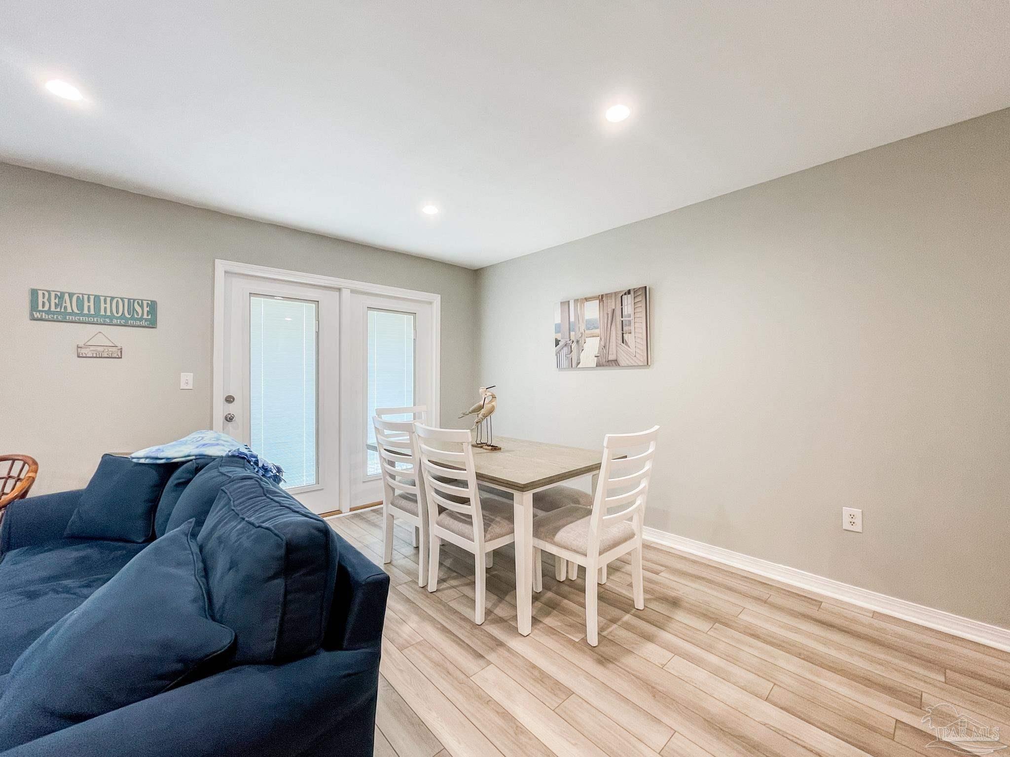 13351 Johnson Beach Road, Unit 402E Pensacola, FL 32507 - Photo 12 of 30 a living room with furniture a wooden floor and a window