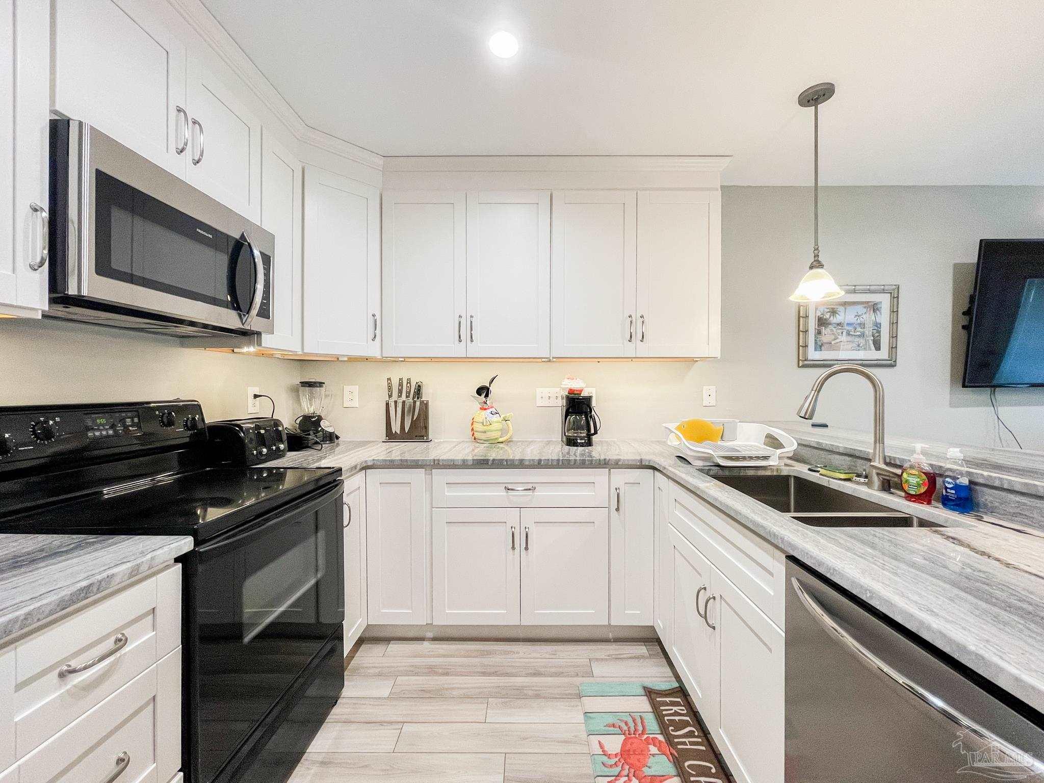 13351 Johnson Beach Road, Unit 402E Pensacola, FL 32507 - Photo 16 of 30 a kitchen with a sink stove and microwave