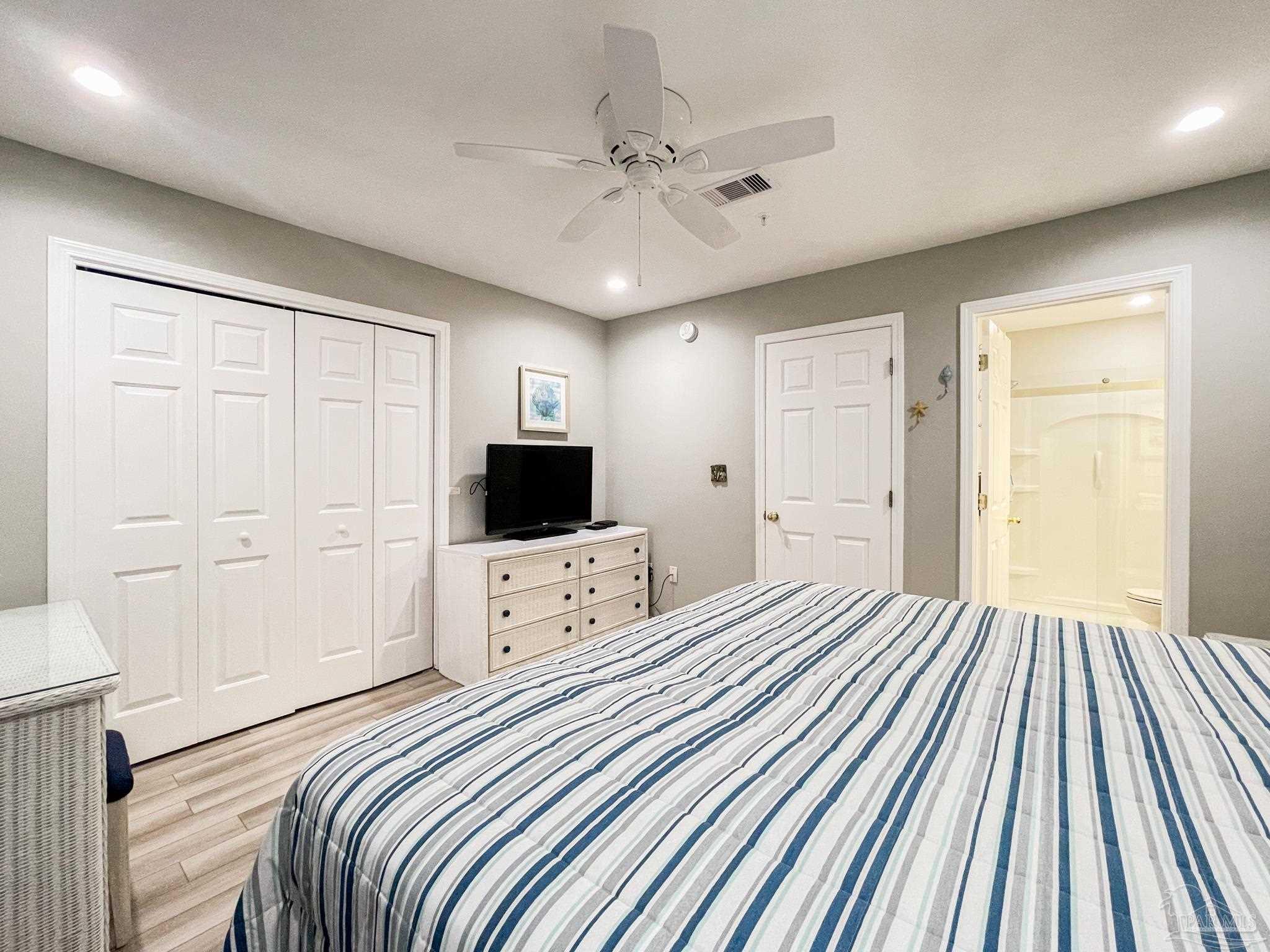 13351 Johnson Beach Road, Unit 402E Pensacola, FL 32507 - Photo 22 of 30 a bedroom with a bed and a flat screen tv