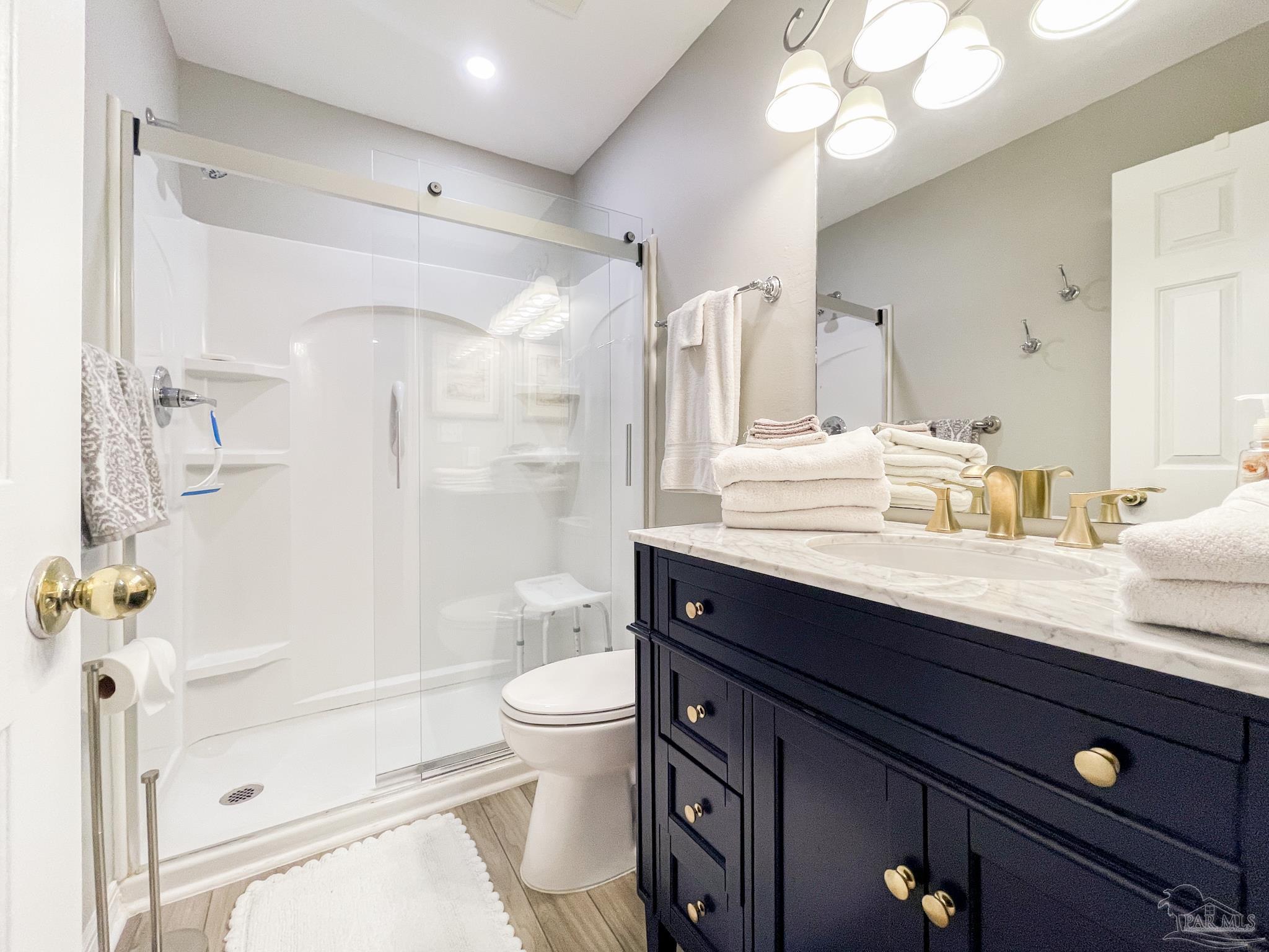 13351 Johnson Beach Road, Unit 402E Pensacola, FL 32507 - Photo 23 of 30 a bathroom with a sink a toilet a mirror and shower