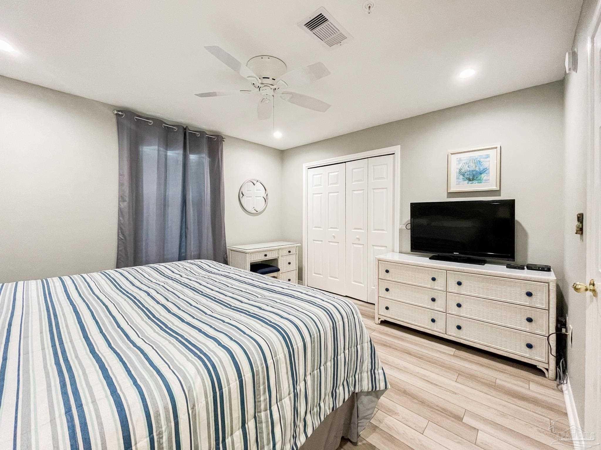 13351 Johnson Beach Road, Unit 402E Pensacola, FL 32507 - Photo 24 of 30 a bedroom with a bed and a flat screen tv