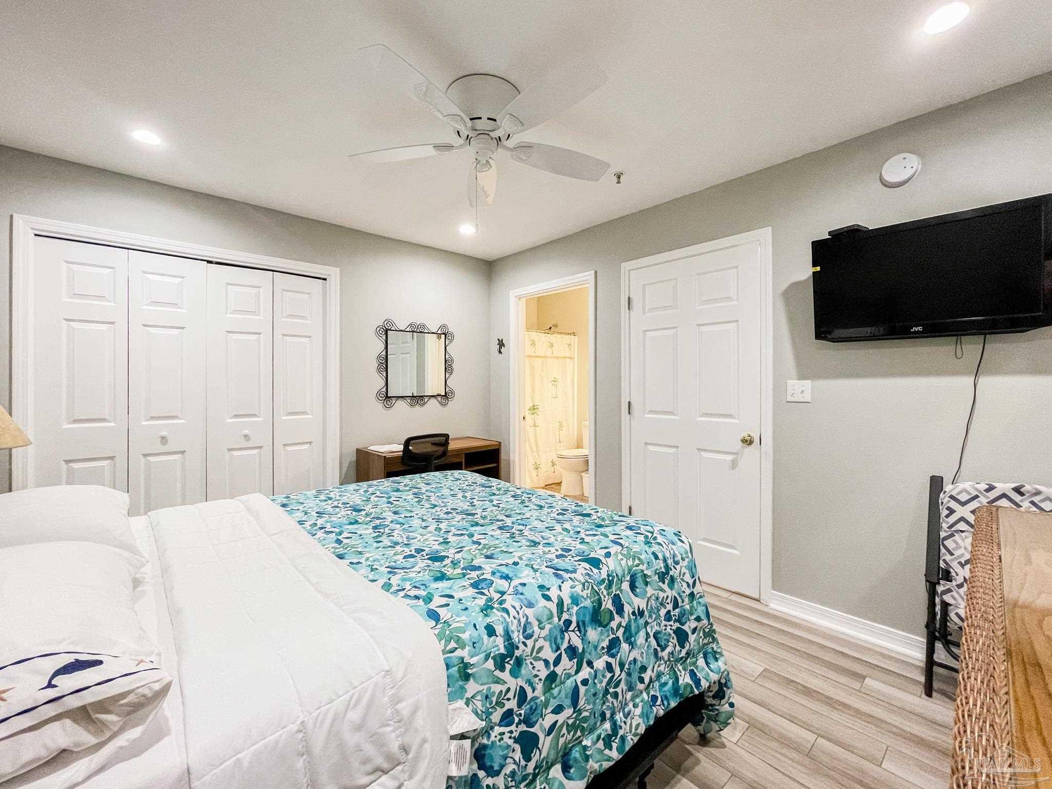 13351 Johnson Beach Road, Unit 402E Pensacola, FL 32507 - Photo 26 of 30 a spacious bedroom with a bed and a flat screen tv