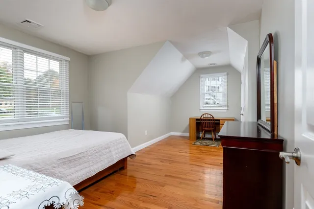 a bedroom with a bed and wooden floor