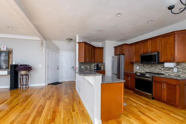 a kitchen with stainless steel appliances granite countertop a stove refrigerator and a microwave