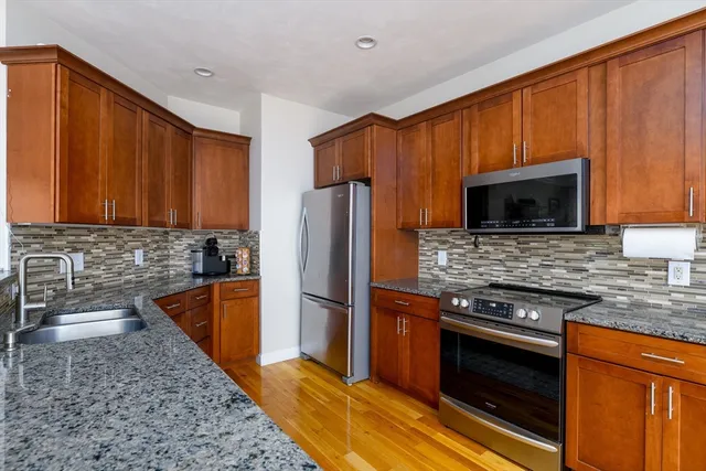 a kitchen with granite countertop stainless steel appliances and wooden cabinets
