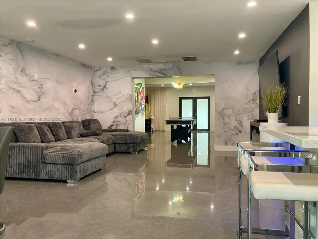 a living room with furniture and a view of kitchen