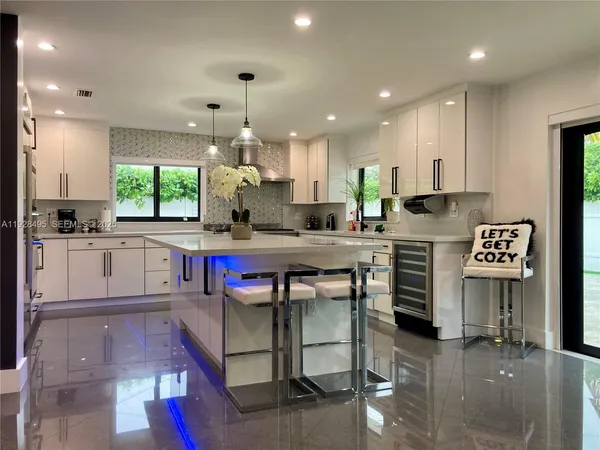 a kitchen with kitchen island granite countertop a sink cabinets and window