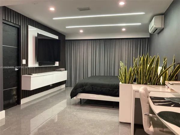 a bedroom with a bed and a potted plant on the dresser