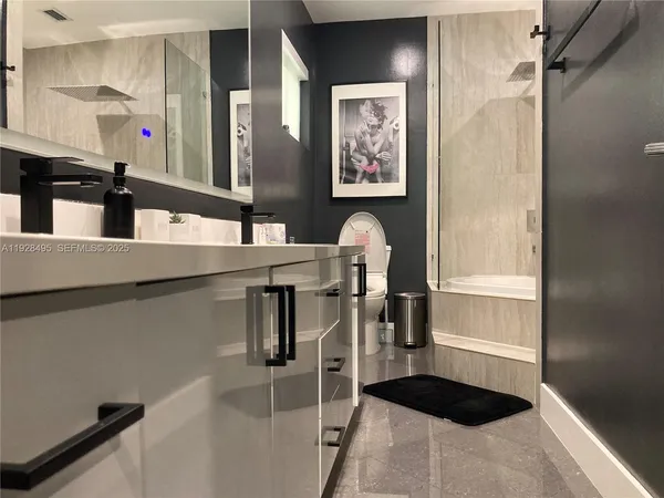 a bathroom with a sink a toilet and shower