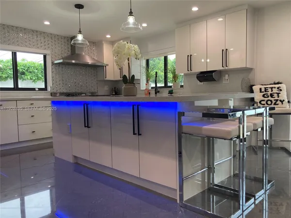 a kitchen with stainless steel appliances kitchen island granite countertop a stove a sink and a microwave