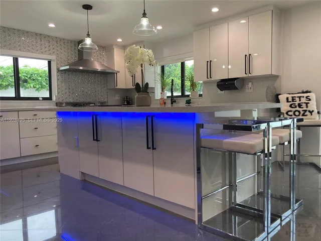 a kitchen with stainless steel appliances kitchen island granite countertop a stove a sink and a microwave