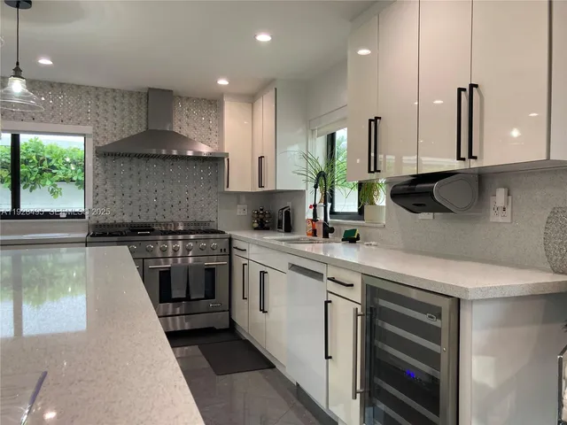 a kitchen with a sink a stove and cabinets