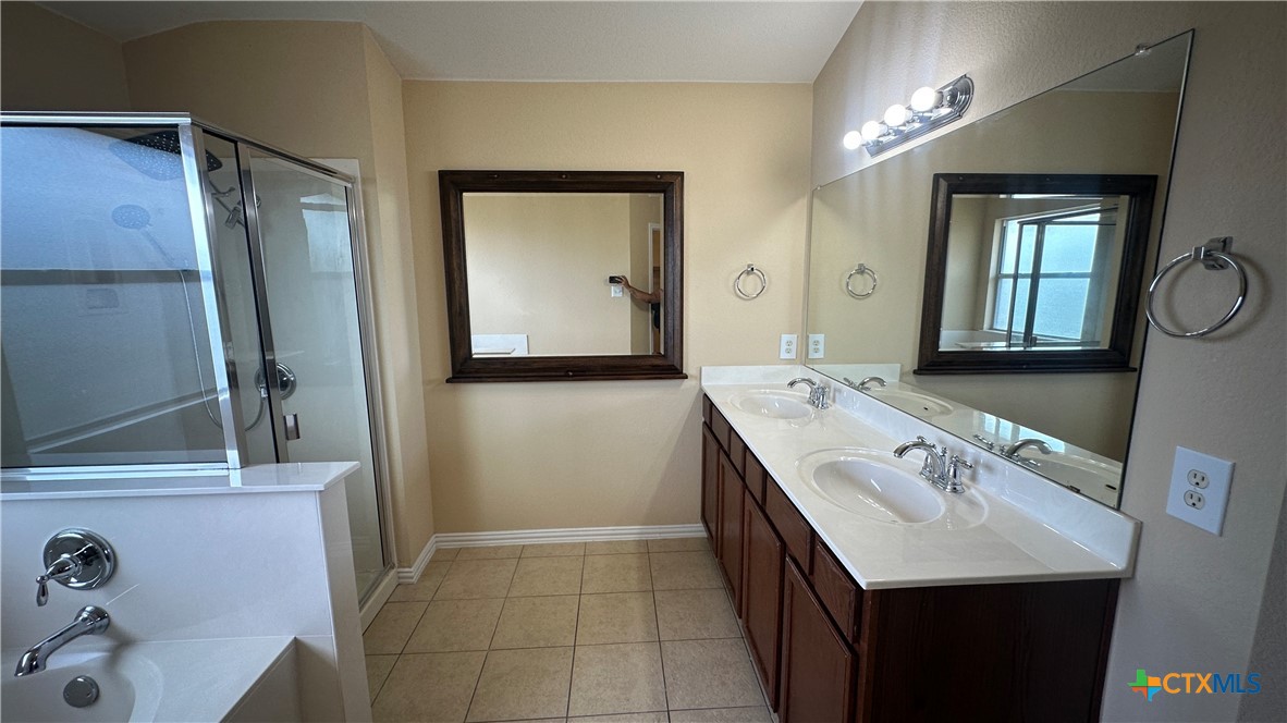834 Red Fern Drive Harker Heights, TX 76548 - Photo 13 of 16 a bathroom with a double vanity sink a mirror and a bathtub