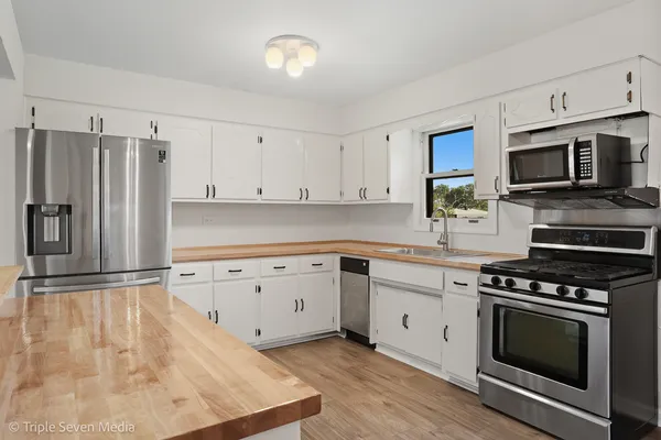 a kitchen with granite countertop a stove top oven and cabinets