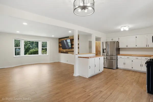 a kitchen with granite countertop a refrigerator stove and sink
