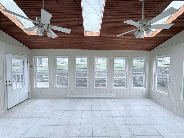 a view of an empty room with a window and a kitchen