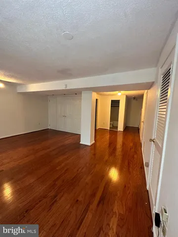 a view of an empty room with wooden floor and floors