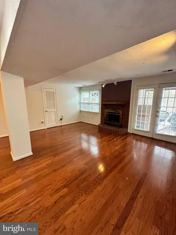 an empty room with wooden floor and fireplace