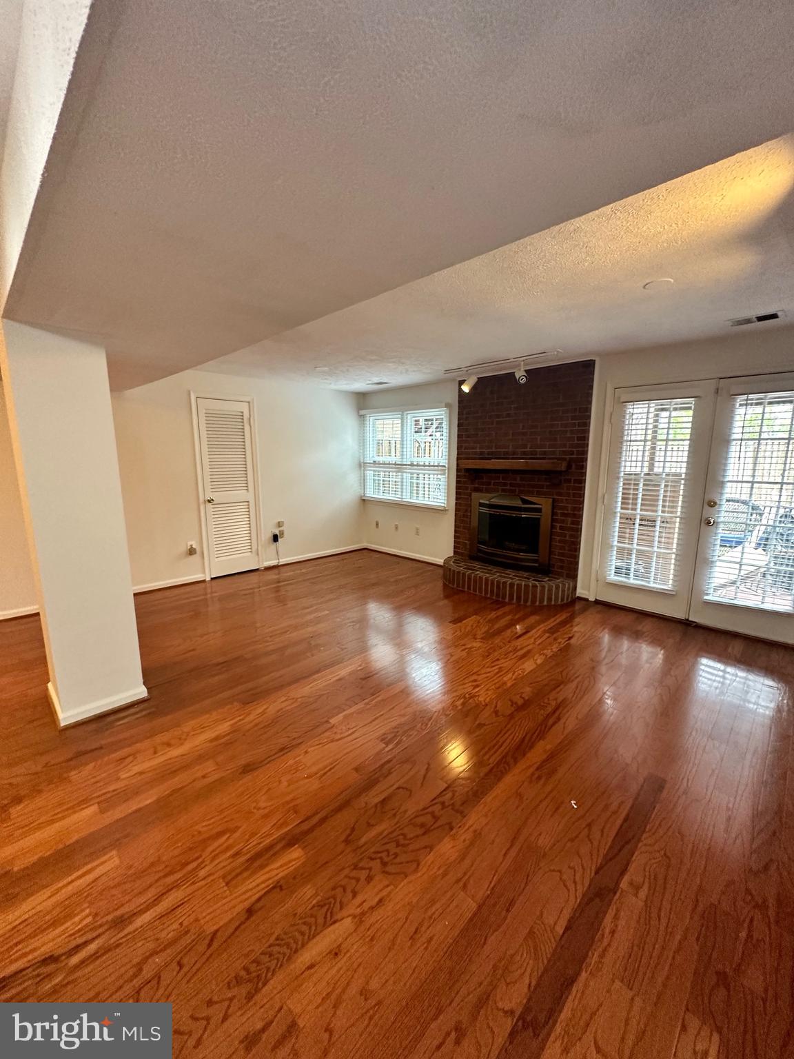 2258 Cartbridge Road Falls Church, VA 22043 - Photo 25 of 35 an empty room with wooden floor and fireplace