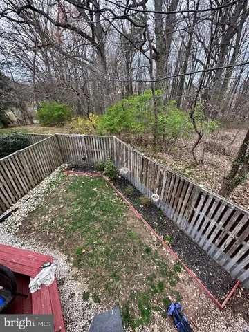 a view of a roof deck with wooden fence and trees